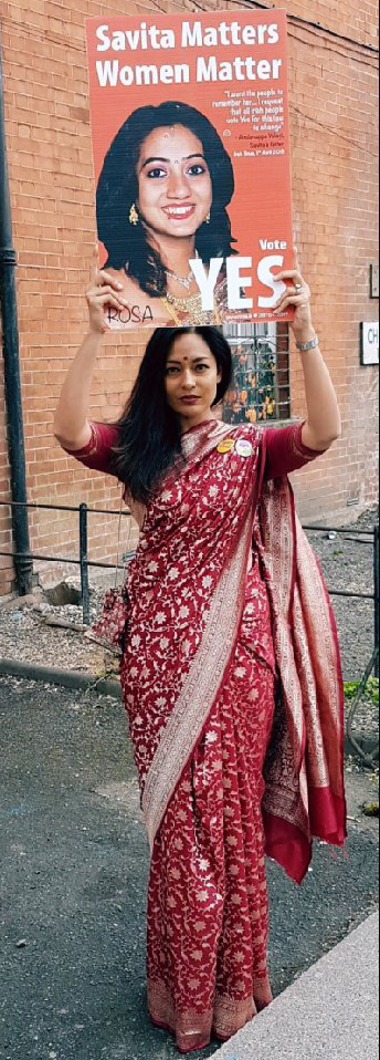 Photograph of a woman in a red wedding dress holding a placard which reads "Savita Matters, Women Matter, Vote YES". The placard features a photograph of Savita Halappanavar