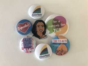 Collection of ARC and repeal-themed badges arranged on a white background